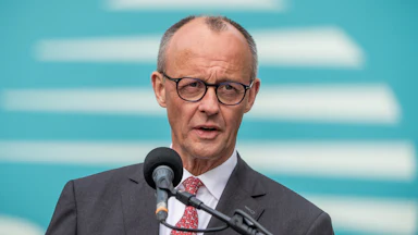German Chancellor Friedrich Merz speaks into a microphone.