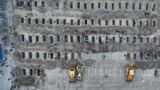 People dig graves for the victims of a strike on a girls' school in the south of Iran