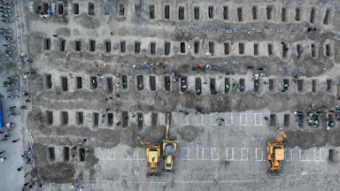 People dig graves for the victims of a strike on a girls' school in the south of Iran