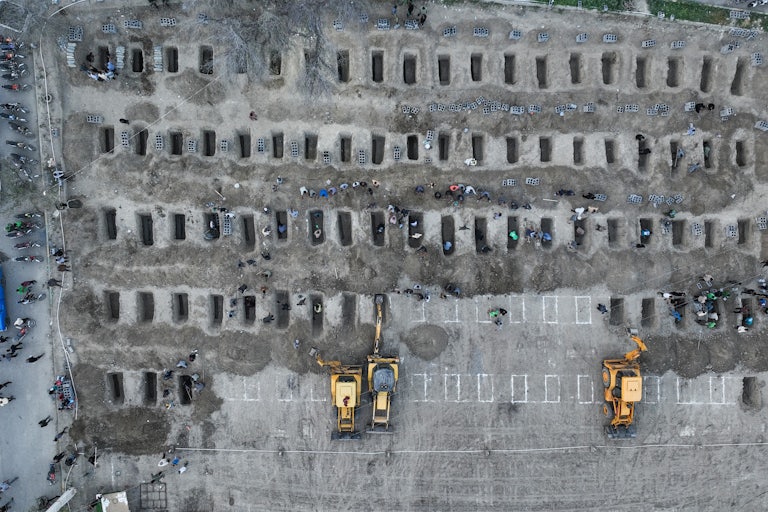 People dig graves for the victims of a strike on a girls' school in the south of Iran