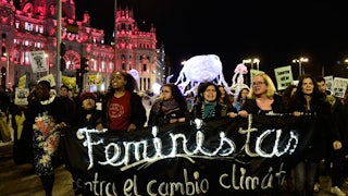 Activists walk holding a banner.
