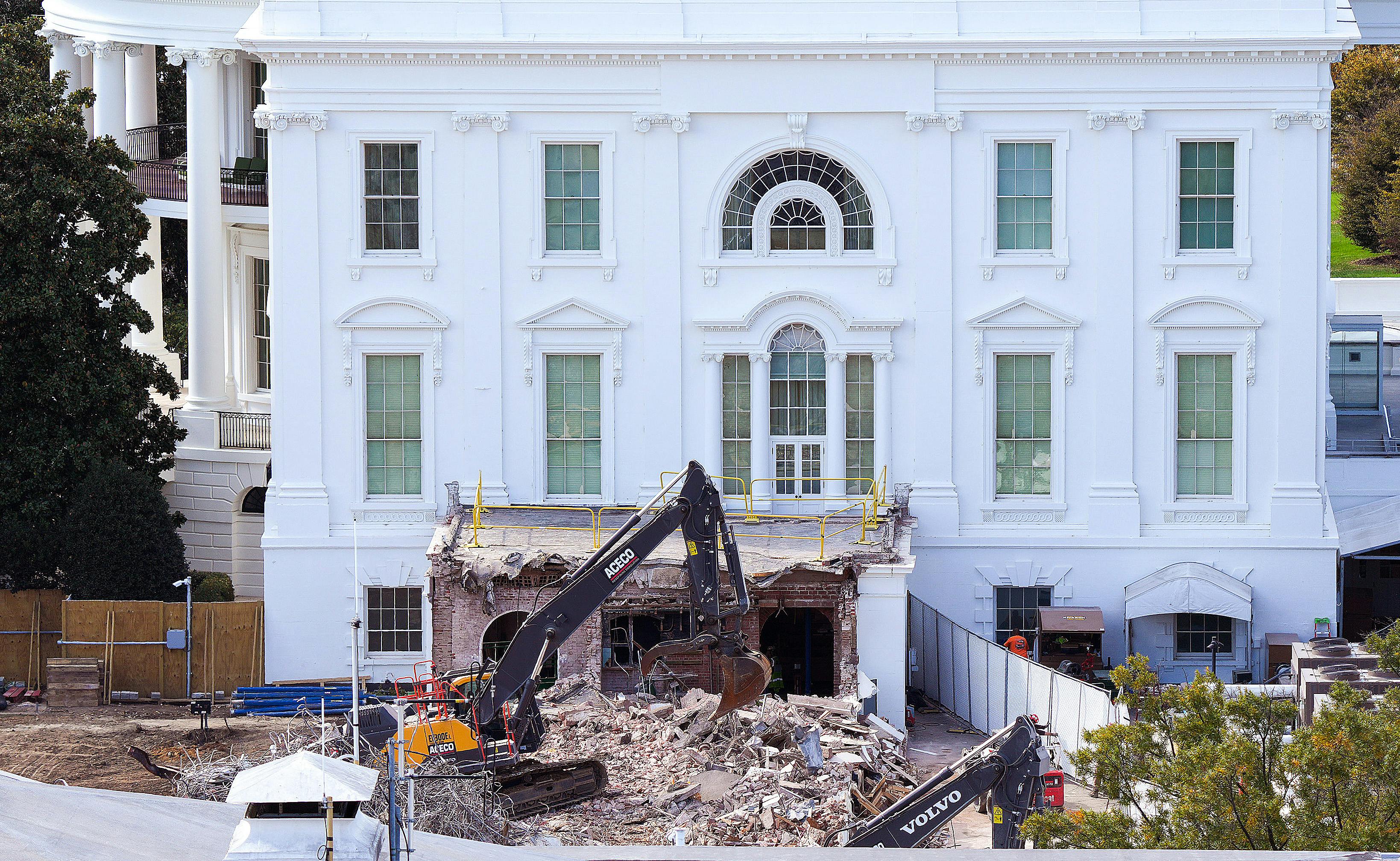 A bulldozer tears down part of the White House.