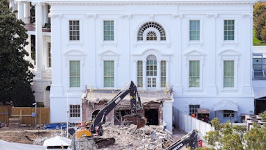 A bulldozer tears down part of the White House.