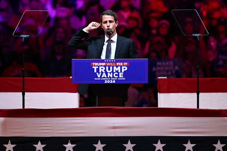 Tony Hinchcliffe touches his ear while speaking at Donald Trump’s rally in Madison Square Garden