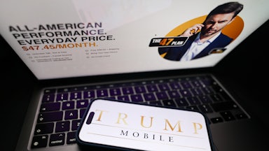 In this photo illustration, the Trump Mobile website displayed on a laptop screen and Trump Mobile logo displayed on a phone screen.