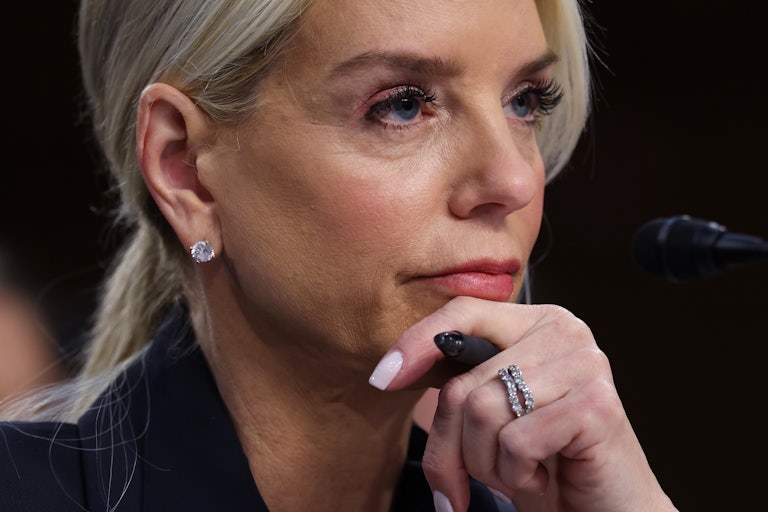 Attorney General Pam Bondi rests her head on her hand as she listens in a Senate hearing.