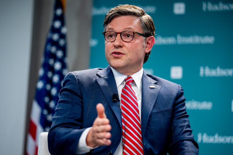 Mike Johnson, seated, speaks and makes a hand gesture in front of Hudson Institute backdrop.