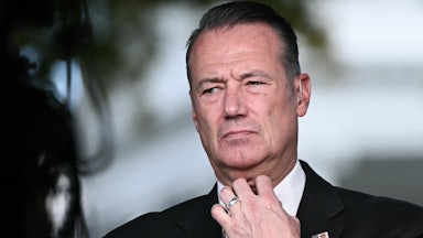 Acting ICE Director Todd Lyons readjusts his neck tie.