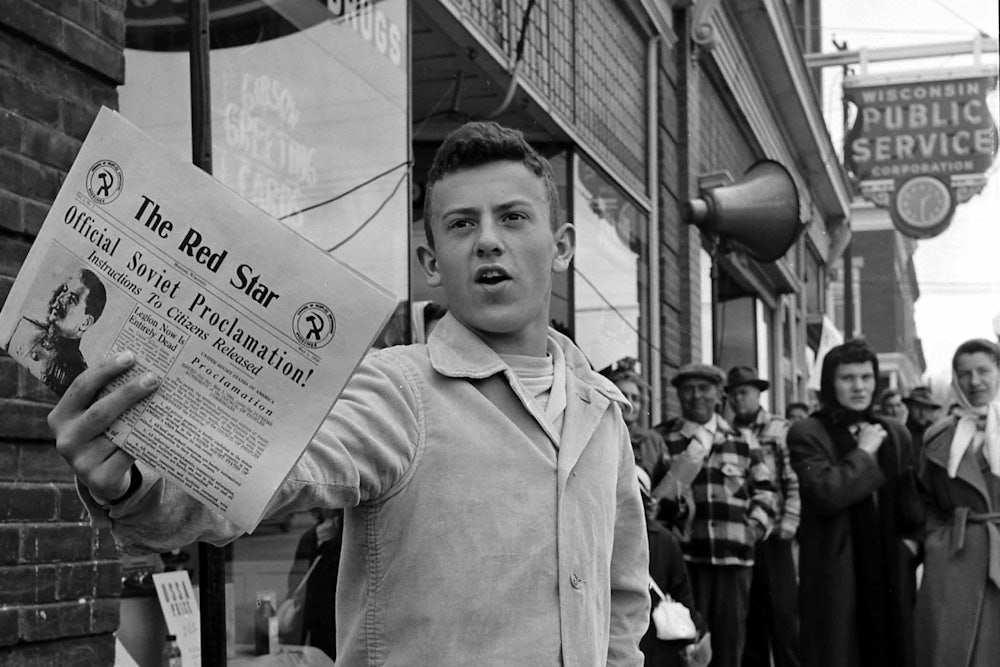 A man selling newspapers during the Mock Communist Invasion of Mosinee, Wisconsin, May 1950.
