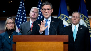 House Speaker Mike Johnson gestures while speaking at a podium