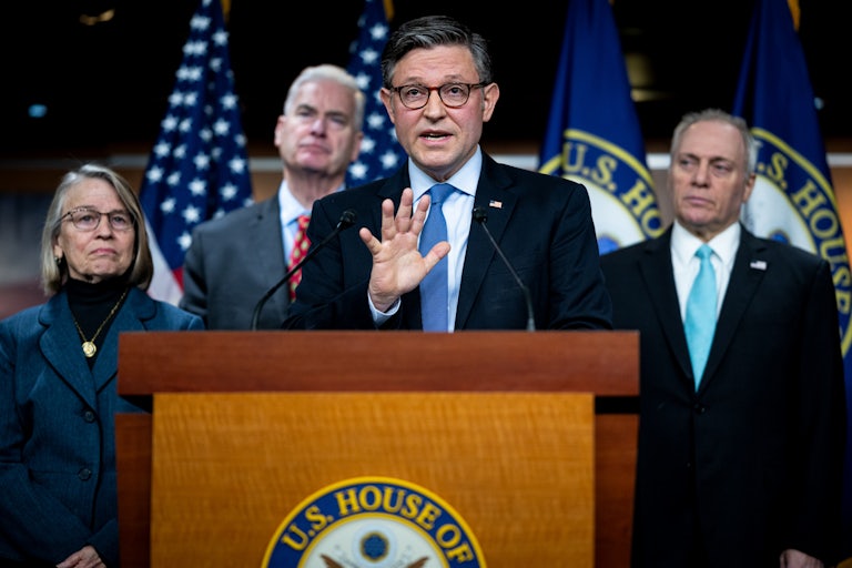 House Speaker Mike Johnson gestures while speaking at a podium