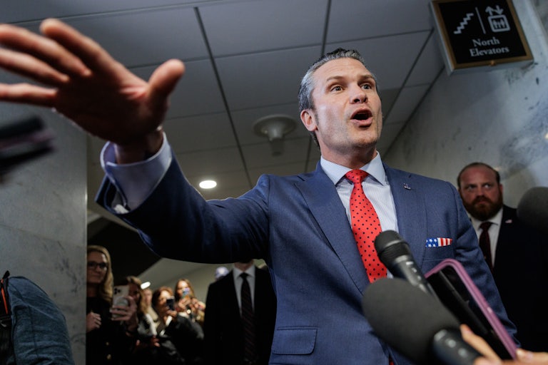 Pete Hegseth gestures while speaking to reporters