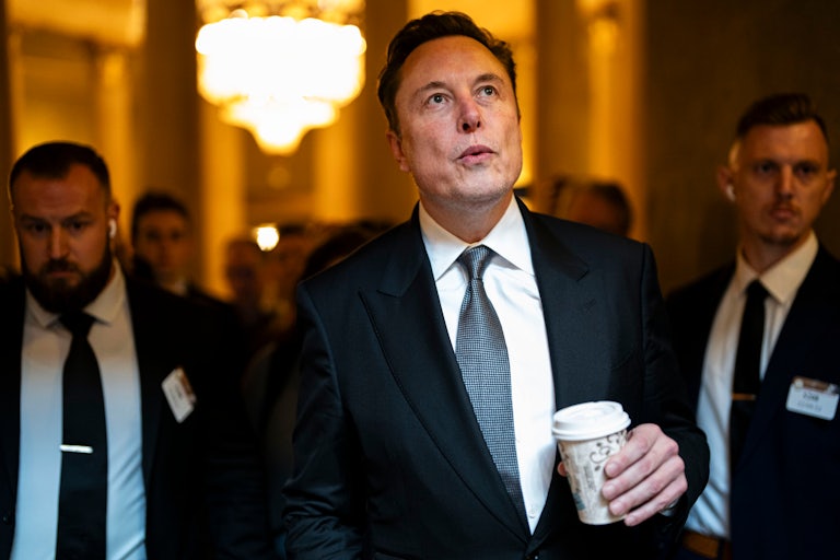 Elon Musk looks up while walking in the U.S. Capitol