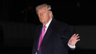 Donald Trump waves while walking outside the White House