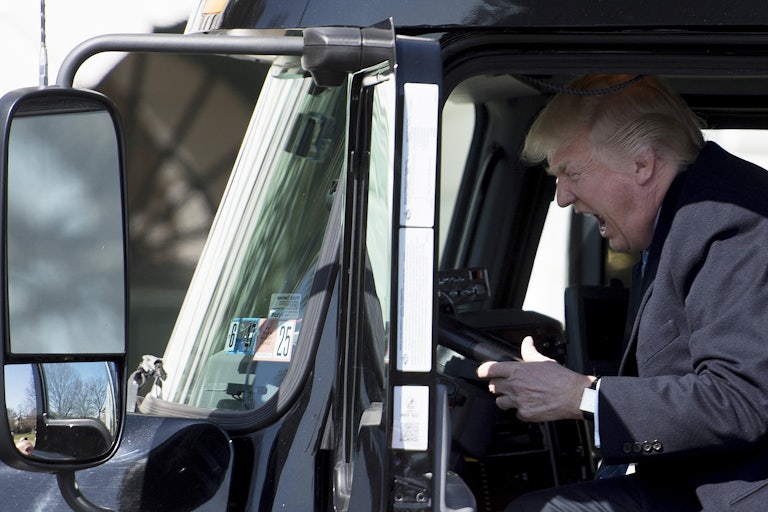 Donald Trump yells into a truck steering wheel.