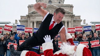 Chris Garten beats up Santa in front of the Tennessee state Capitol as people hold up his campaign signs behind him.