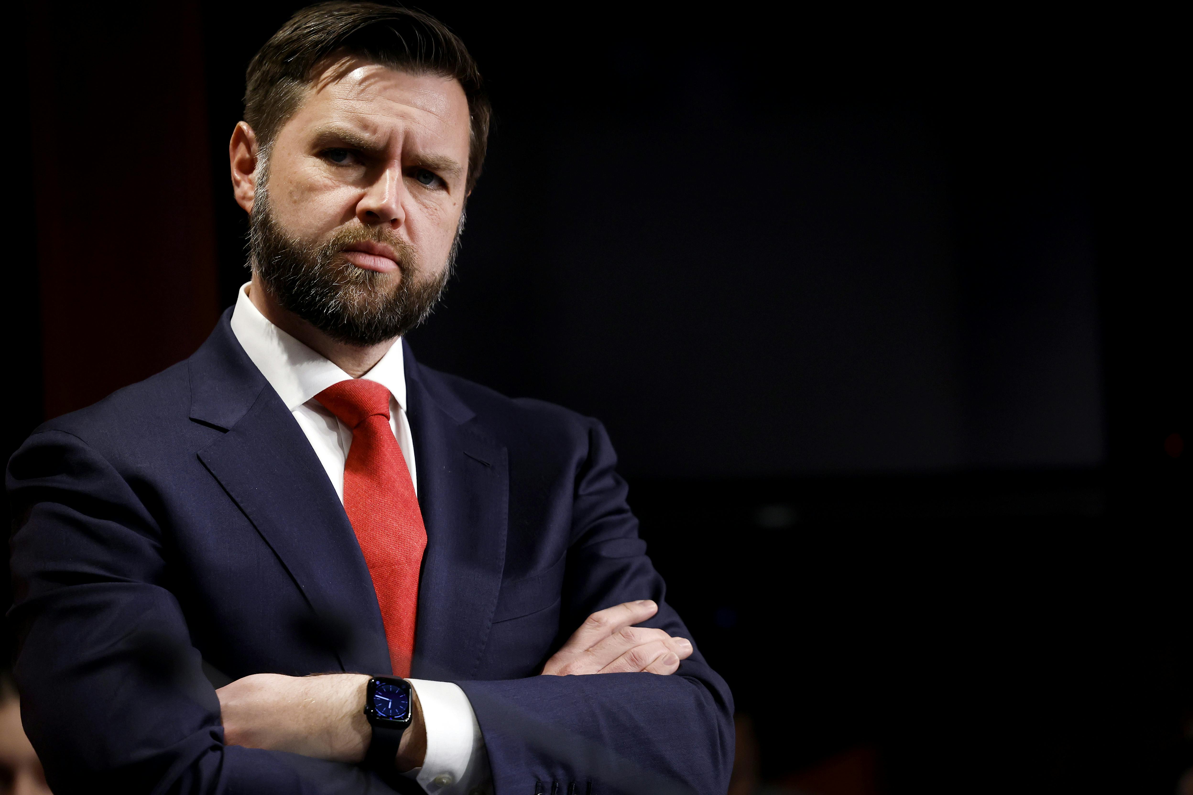 JD Vance with his arms crossed, looking kind of angry