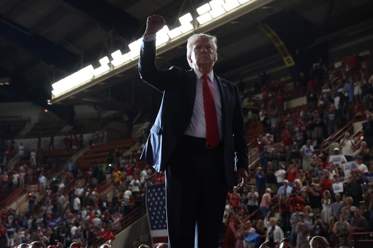 Donald Trump holds his fist up as supporters watch at a campaign rally