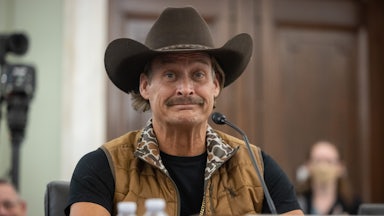 Kid Rock sits at a microphone in a Senate hearing