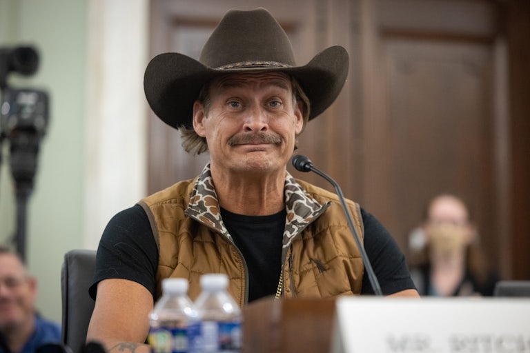 Kid Rock sits at a microphone in a Senate hearing