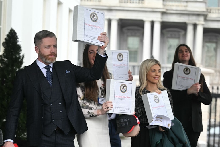 Far-right activists stand outside the White House and hold up binders that allegedly contain documents on Jeffrey Epstein