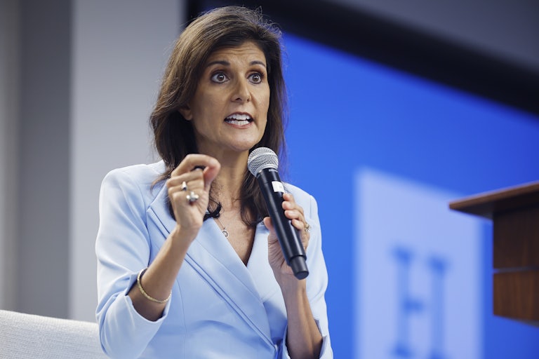 Nikki Haley speaks on a mic and makes a hand gesture for emphasis