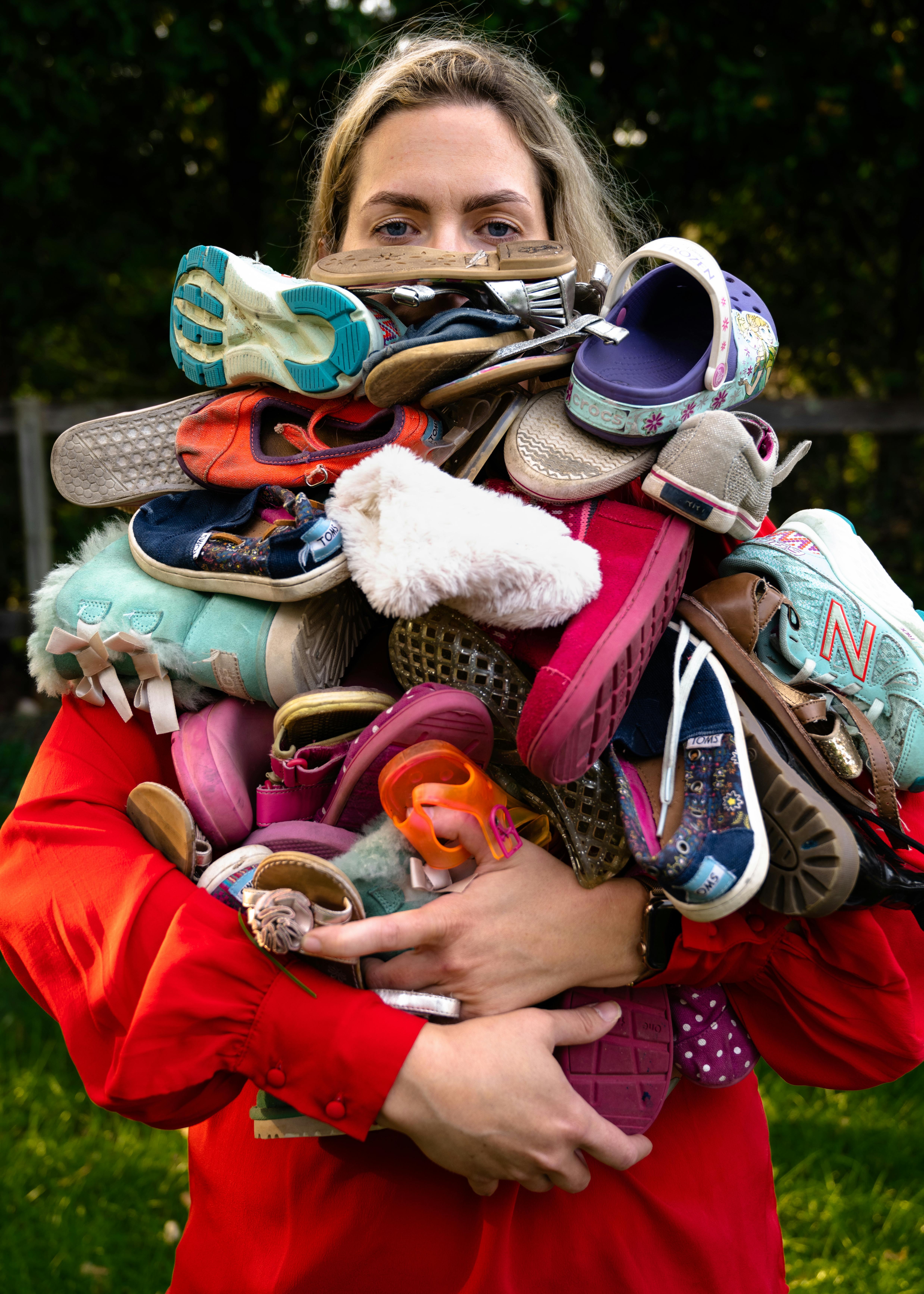 A tired mom carries a huge pile of laundry that almost covers her face.  The title is Optimizes Efficiency  from the series “Résumé of a Stay at Home Mom” by 
