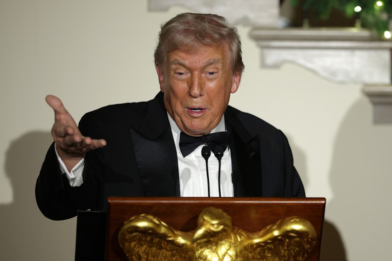 Donald Trump speaks at a lectern while stretching out a hand for emphasis.