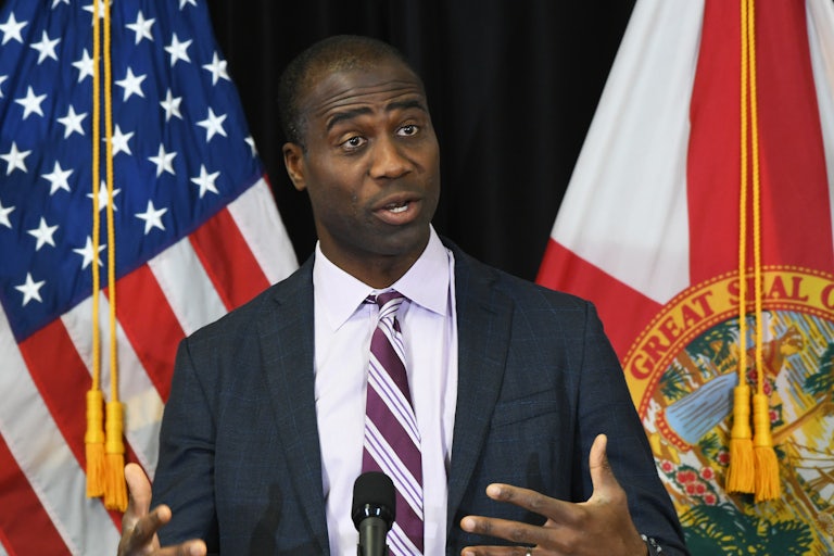 Florida Surgeon General Joseph Ladapo speaks in front of the U.S. and Florida flags.