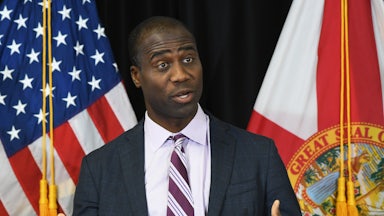 Florida Surgeon General Joseph Ladapo speaks in front of the U.S. and Florida flags.