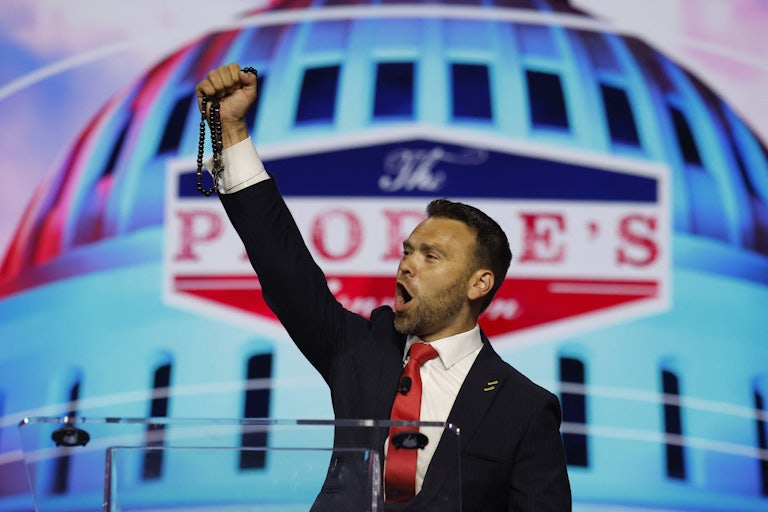 Jack Posobiec raises his fist in victory and yells