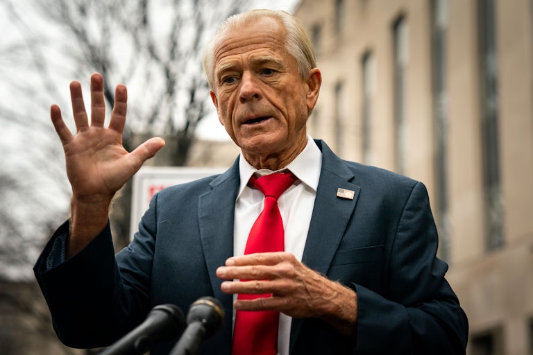 Peter Navarro stands outside before several mics. He raises his hand and looks distressed.