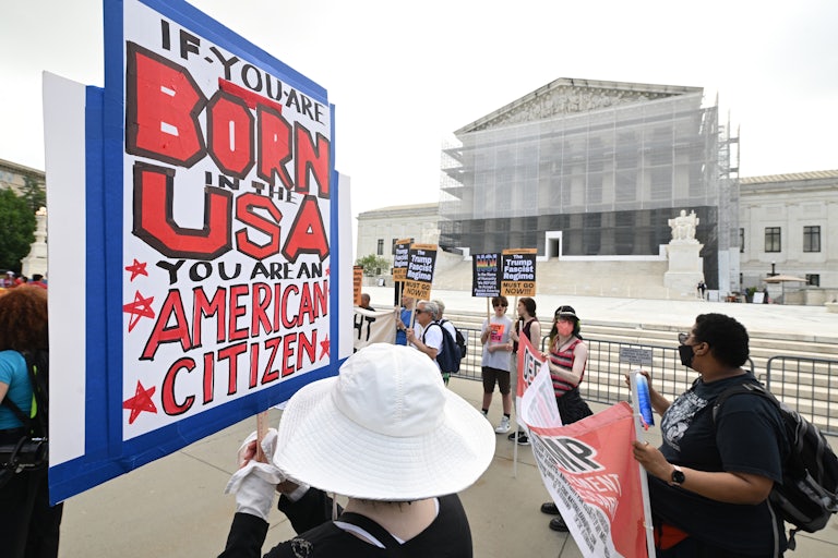 A person holds a sign that says, "If you are born in the USA, you are an American citizen" at a protest in support of birthright citizenship outside the Supreme Court