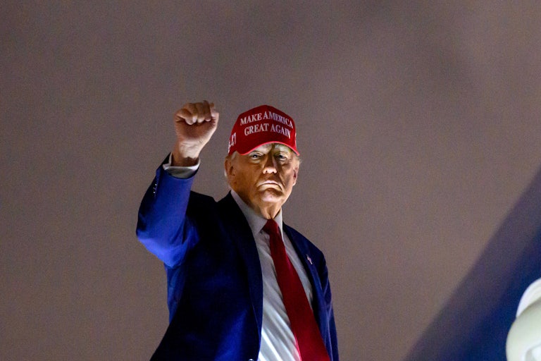 Donald Trump holds up his fist while boarding Air Force One