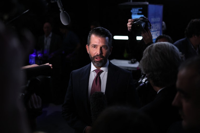 Donald Trump Jr. surrounded by press in the spin room after the vice presidential debate