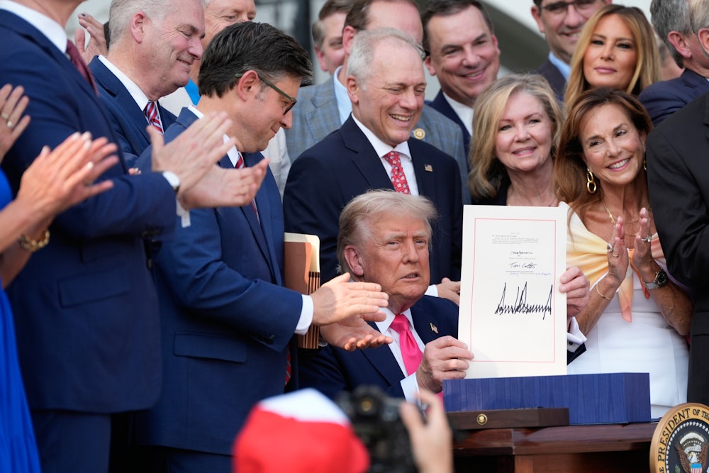 President Donald Trump holds up the “One, Big Beautiful Bill” Act that was signed into law as during an Independence Day military family picnic on the South Lawn of the White House on July 04, 2025 in Washington, DC.