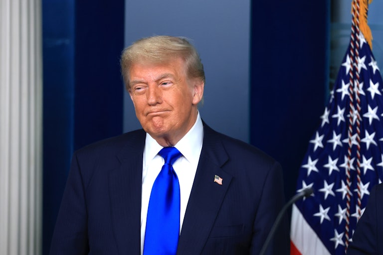Donald Trump stands to the side during a press conference