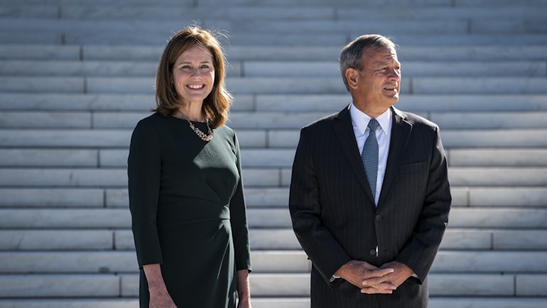 Justice Amy Coney Barrett and Chief Justice John Roberts stand on the steps of the Supreme Court.
