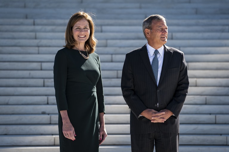 Justice Amy Coney Barrett and Chief Justice John Roberts stand on the steps of the Supreme Court.