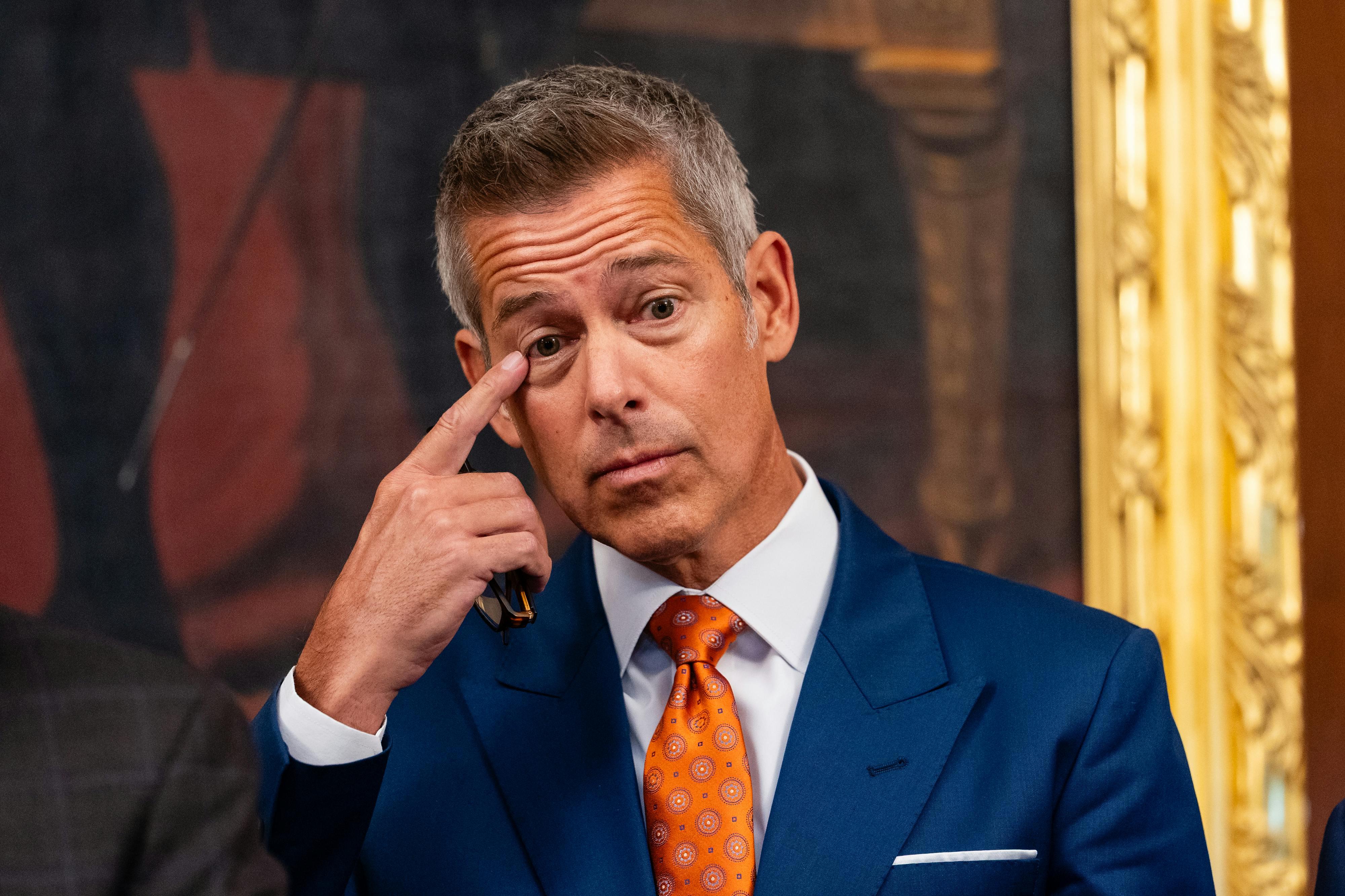 Transportation Secretary Sean Duffy puts a finger near his eye.