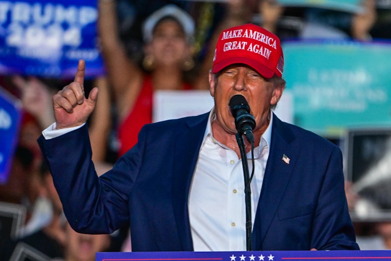 Donald Trump gestures as he speaks into a microphone