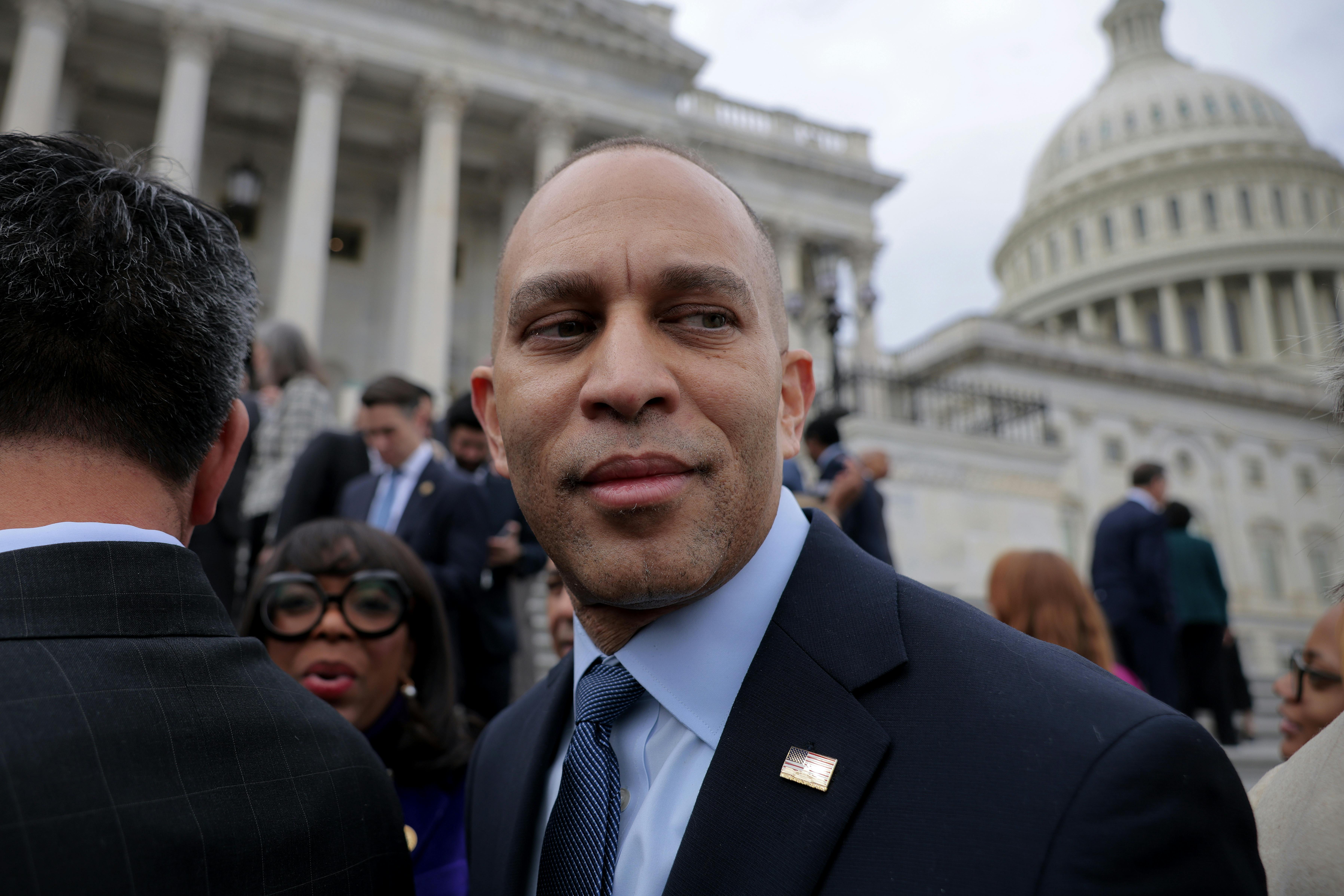 Hakeem Jeffries looks back as he stands in front of the US Capitol. 