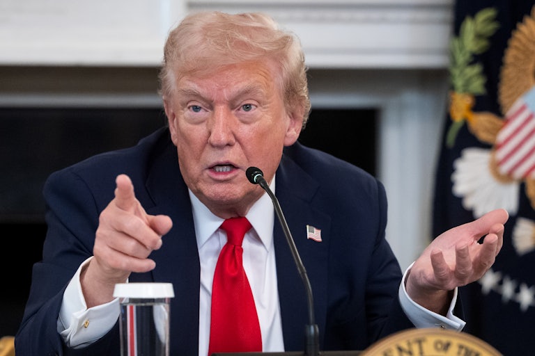 Donald Trump gestures while speaking into a microphone