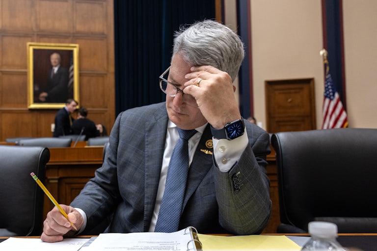 Representative Brandon Williams rests his forehead on his hand while writing