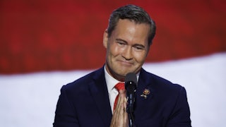 Mike Waltz clasps his hands together in front of a microphone.