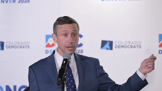 Ken Martin gesticulates while speaking into a microphone.
