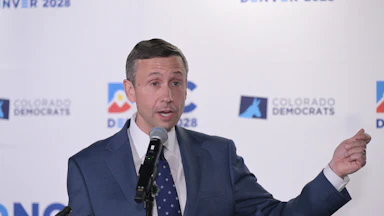 Ken Martin gesticulates while speaking into a microphone.
