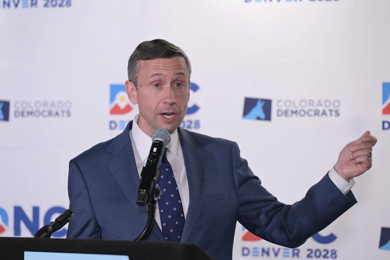 Ken Martin gesticulates while speaking into a microphone.