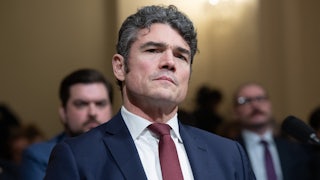 Ex-Director of the National Counterterrorism Center Joe Kent tilts his head while sitting in a House committee hearing