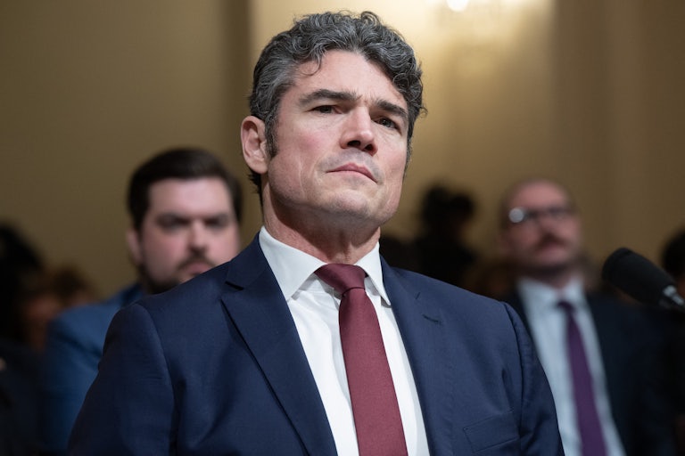 Ex-Director of the National Counterterrorism Center Joe Kent tilts his head while sitting in a House committee hearing